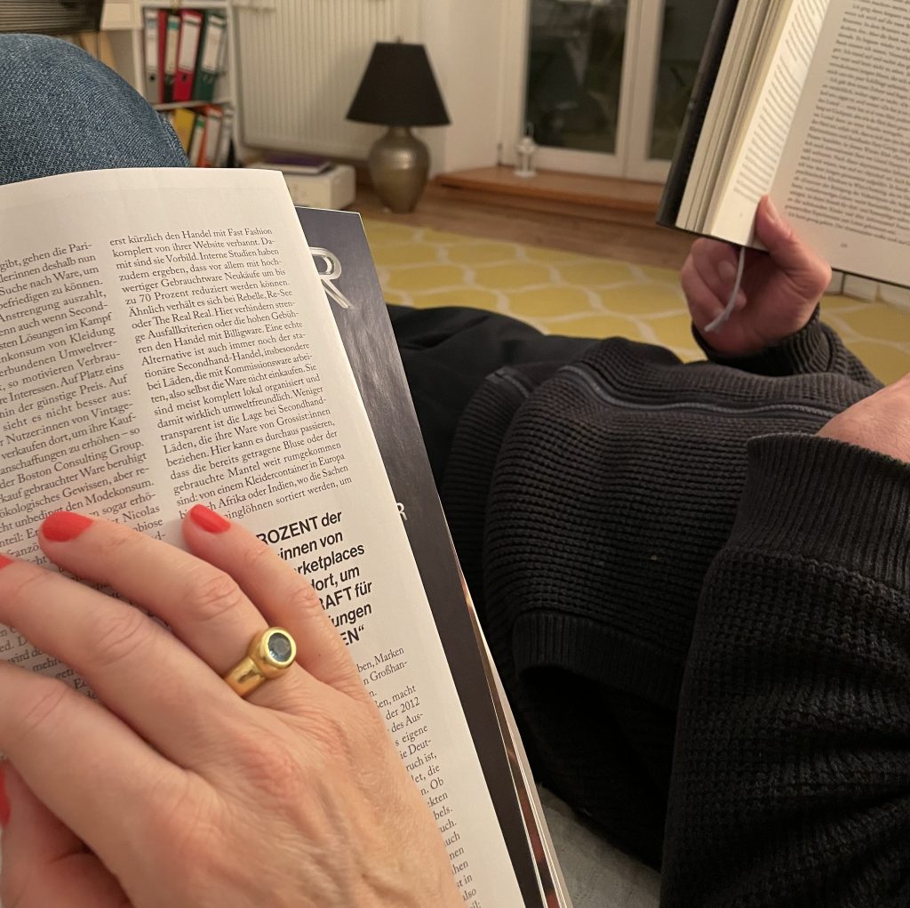 Stadtlocke Susanne Graue mit stylischem Nagellack beim Lesen. 